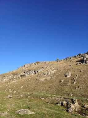 Dağları ve mavi gökyüzü olan güzel bir manzara.