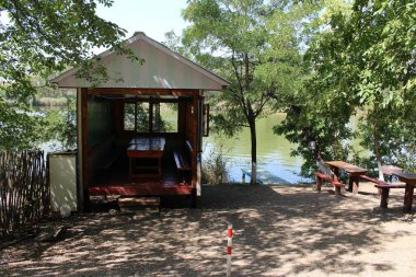 Nehirde çadırı olan ahşap bir ev