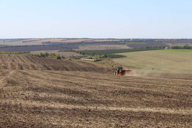 Tarlalarda açık toprağı olan bir traktör..
