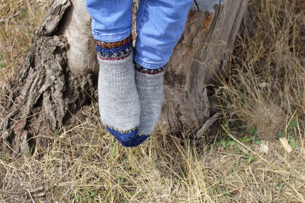 feet of a girl in a woolen hat and jeans
