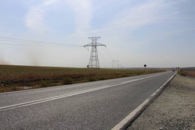 Dağlarda elektrik hatları olan bir yol