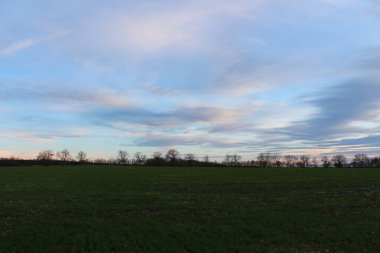 Gökyüzü bulutlu kırsalda güzel bir gün batımı.