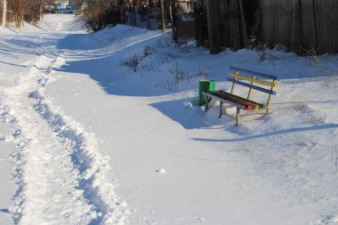 Parkta ahşap çitlerle kaplı kış manzarası