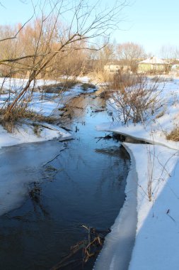 Bir nehir ve donmuş bir göl olan kış manzarası