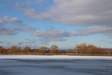 Uzakta treni olan donmuş bir göl.