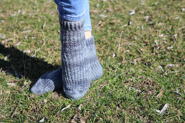woman wearing a knitted knitted socks on grass in the park.