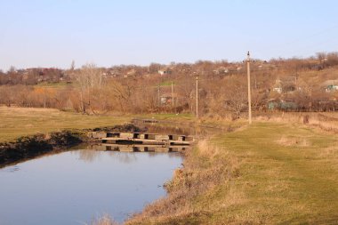 Köyde küçük bir nehri olan paslı bir çit..