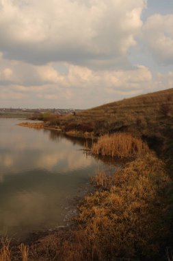 Arkasında bulutlu bir gökyüzü olan güzel bir nehir manzarası.