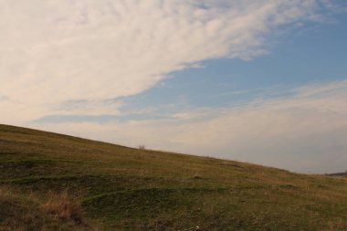 Arka planda mavi gökyüzü ve bulutlu manzara