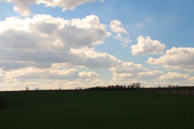 Bulutları ve mavi gökyüzü olan güzel bir manzara.