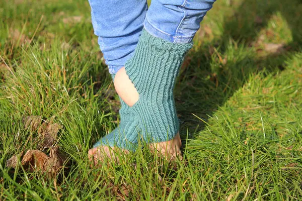 woman \'s foot wearing green socks on the grass.