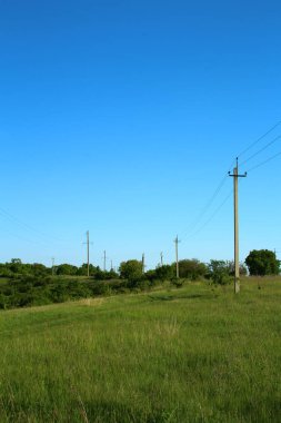 Yeşil bir alanın yüksek açılı görüntüsü ve mavi gökyüzünün arka planında bir çit.