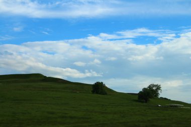 Dağları ve bulutlu gökyüzü olan güzel bir manzara.