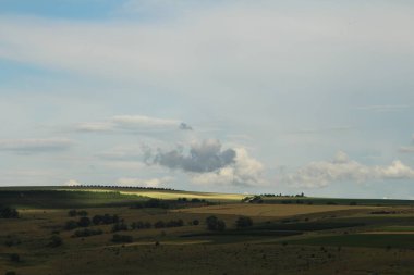 Dağları ve bulutlu gökyüzü olan güzel bir manzara.