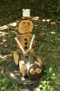 Büyük beyaz şapkalı, kırmızı fiyonklu eski tahta bebek.