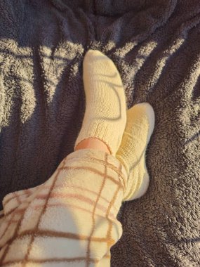 Beyaz battaniyeli bir kadın ayağının yakın çekimi.