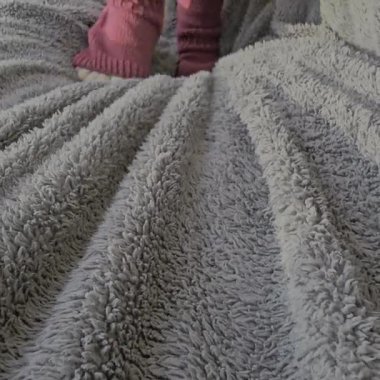 Beyaz bir battaniye tutan birinin yakın plan fotoğrafı.