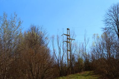Mavi gökyüzünün arka planında yüksek voltajlı elektrik hatları.
