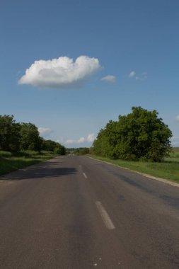 Mavi gökyüzü ve beyaz bulutlu yol, yolun ortasındaki yol..