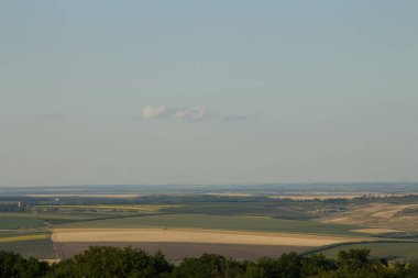 Tarlaları, çayırları ve tepeleri olan yaz manzarası