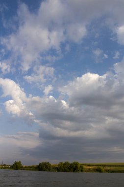 Bir yaz gününde beyaz bulutlu mavi gökyüzü olan nehrin manzarası. yüksek kaliteli fotoğraf