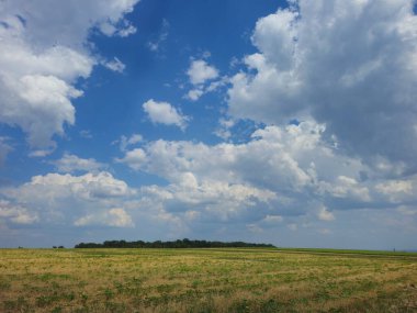 Beyaz bulutlu yeşil alan ve mavi gökyüzü arkaplanı