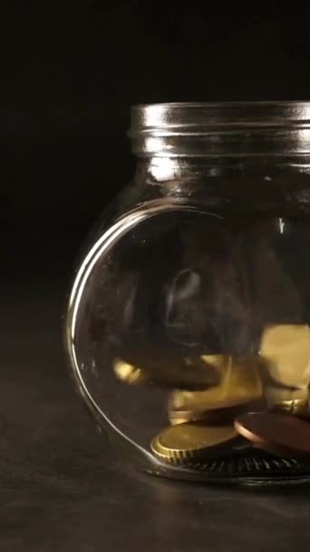 Vallende Gouden Munten Een Glazen Pot Zwarte Achtergrond — Stockvideo