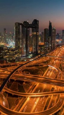 Timelapse of car traffic transportation above circle roundabout road in Asian city. Dubai skyline, Dubai city aerial view. Public transport, commuter city life concept