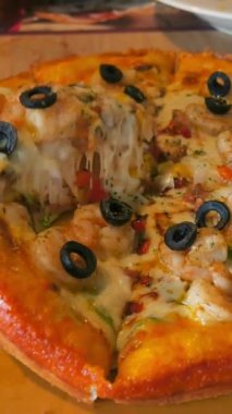 İnsan eli açık kutudan lezzetli İtalyan pizzasından bir dilim alır. Fast food lezzetli ev yapımı yemek. Pizza üst görünümü