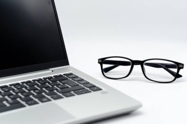 Görünüm gözlüklü ve beyaz arkaplanı olan bir dizüstü bilgisayar klavyesi