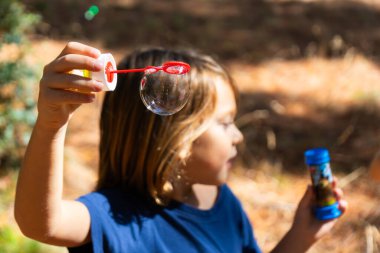 Sabun köpüğü tutan çocuk