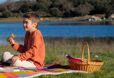 Mutlu çocuk doğada piknik yapıyor.