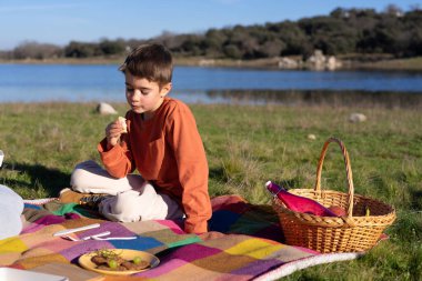 Çocuk doğada piknik yapıyor.