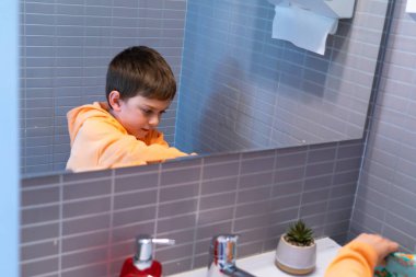 Banyodaki çocuk aynada yansıyor.