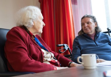 Huzurevinde konuşan yaşlı bir anne ve kız.