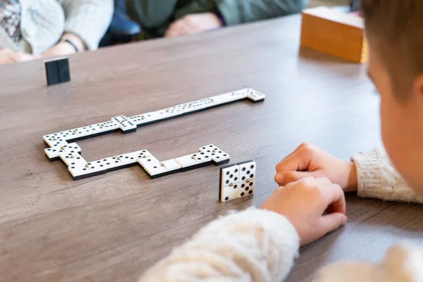Boy playing dominoes with his great-grandmother in a nursing home