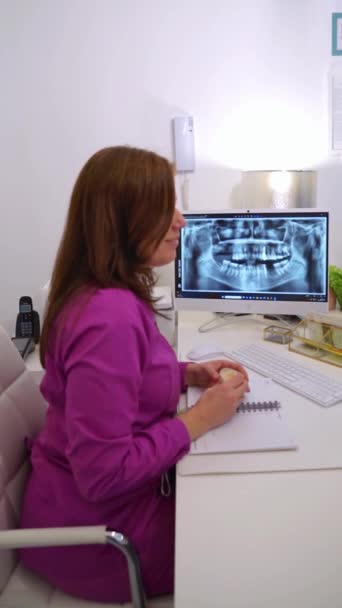 Vrouwelijke Tandarts Legt Een Röntgenfoto Uit Aan Haar Patiënt Haar — Stockvideo