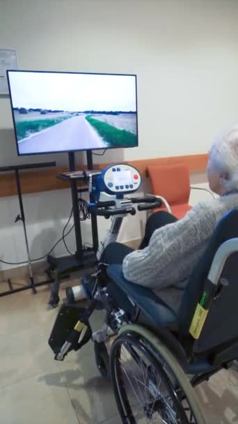 Пожилая Женщина Делает Реабилитационные Упражнения Стационарном Велосипеде Реабилитационной Больнице — стоковое видео