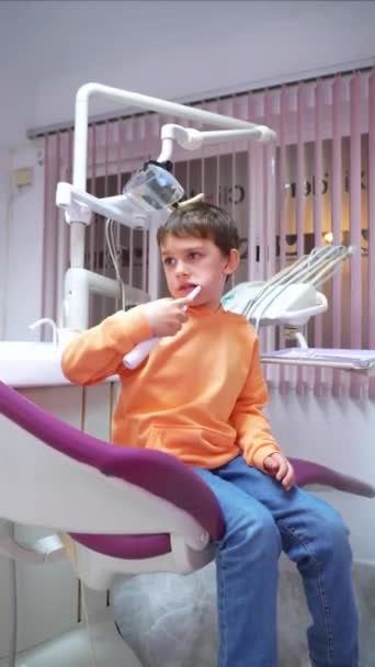Αγόρι Δοκιμάζει Ηλεκτρική Οδοντόβουρτσα Οδοντιατρική Κλινική — Αρχείο Βίντεο