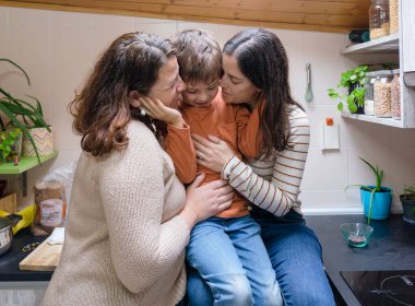 Oğlan ve iki annesi evlerinin mutfağında birbirlerini şımartıyorlar.