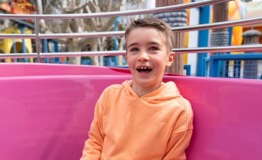 Çocuk bir lunaparktaki kupa gösterisinde çok mutlu gülüyor.