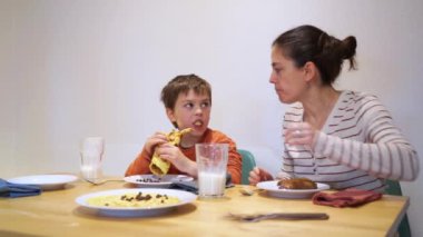 Anne ve oğlu evde birlikte kahvaltı yapıyor.