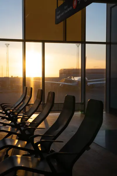 Airport waiting room with a bay window at sunset