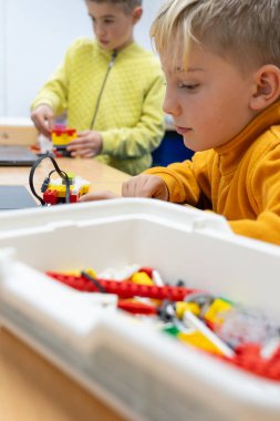 Robotik sınıfındaki çocuklar bilgisayarla robot yapıyorlar.