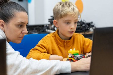 Bilgisayar öğretmeni bir çocuğa öğretiyor