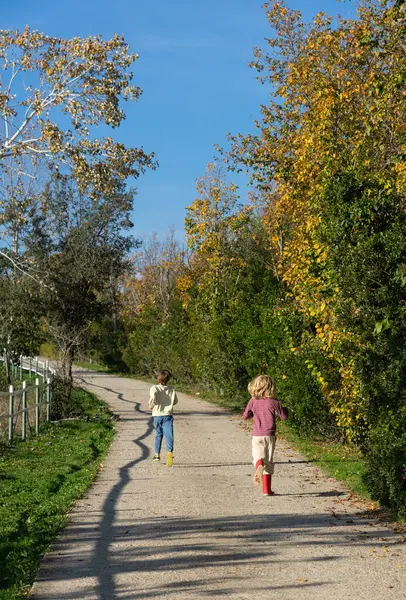 Two children running along a path in the countryside