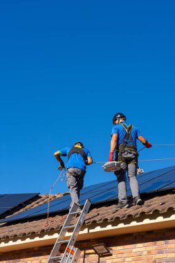 Güneş paneli kurucuları bir eve güneş enerjisi yüklüyor