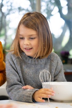 Çocuk evde yemek pişiriyor.