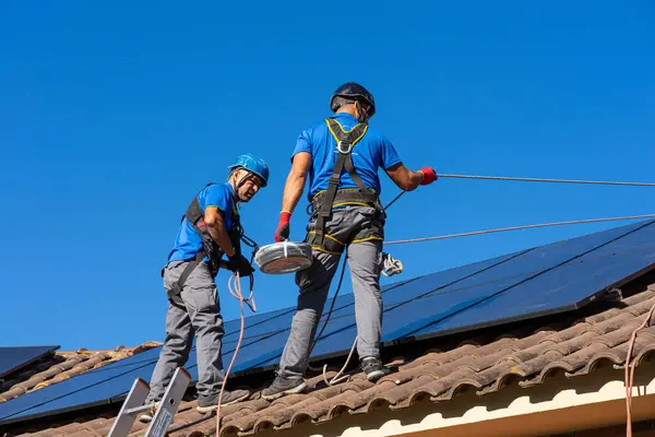 Two men installing solar panels for energy self-sufficiency