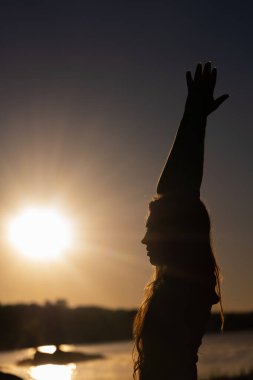 Yoga yapan kadın şafakta meditasyon yapıyor.